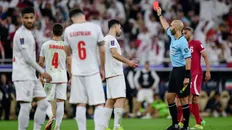 بازیکنان تیم ملی ایران در مقابل داور، داور درحال نشان دادن کارت قرمز به مهدی طارمی