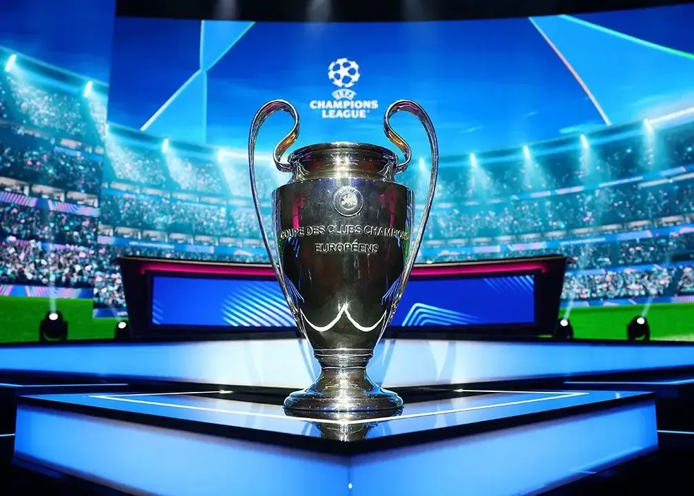 تصویر جام قهرمانی لیگ قهرمانان اروپا (UEFA Champions League) بر روی سکو در یک استادیوم فوتبال