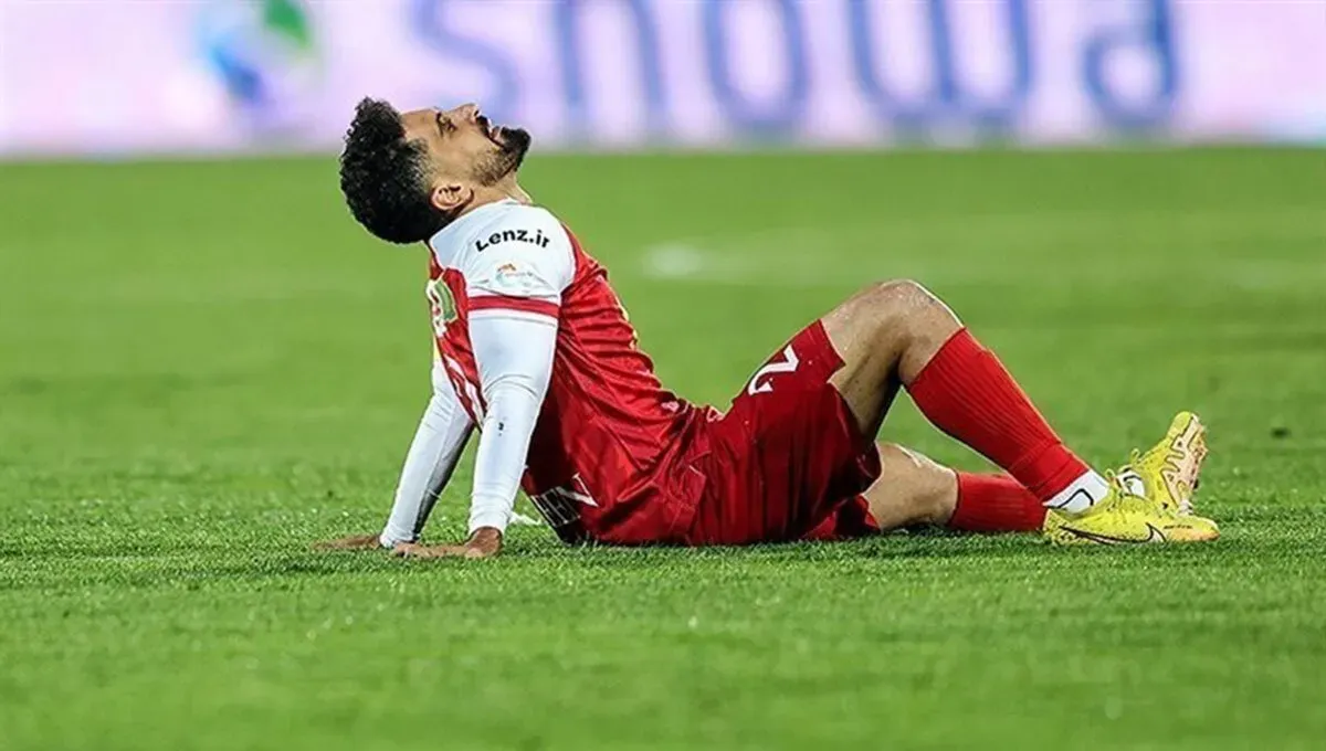 امید عالیشاه با لباس پرسپولیس روی زمین نشسته